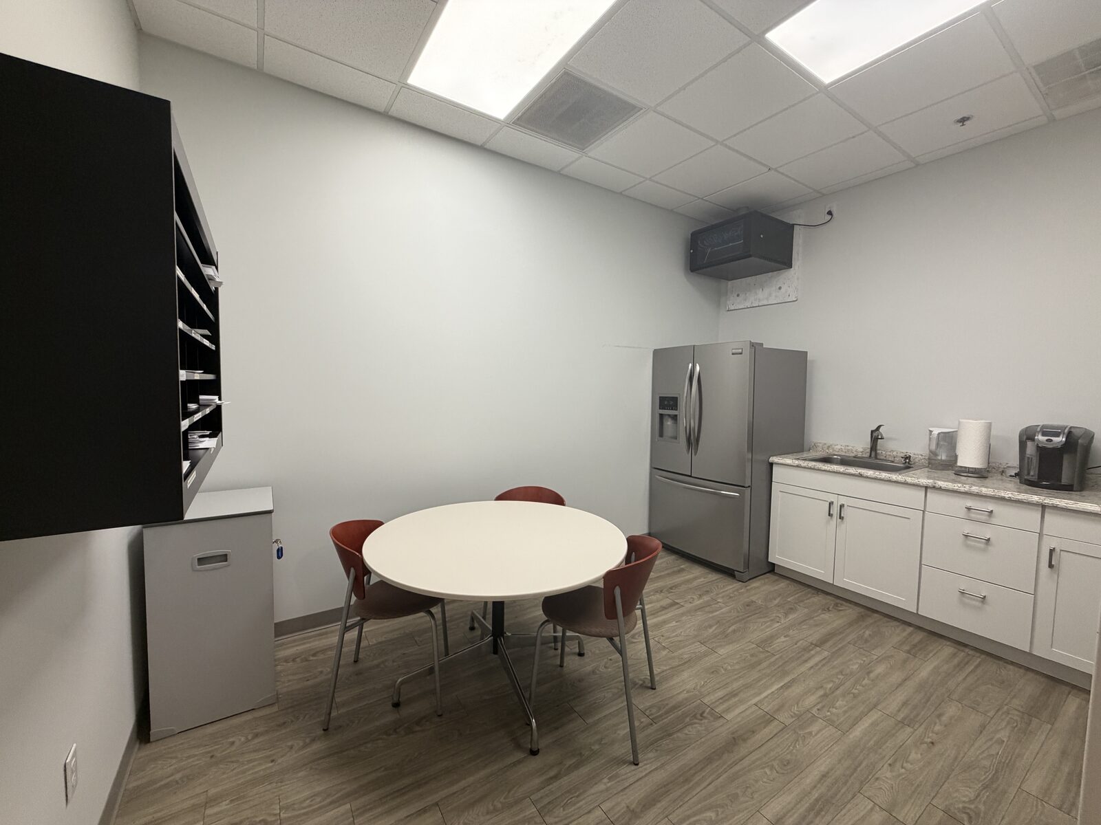 Conference room with wooden table, six chairs, and wall-mounted display